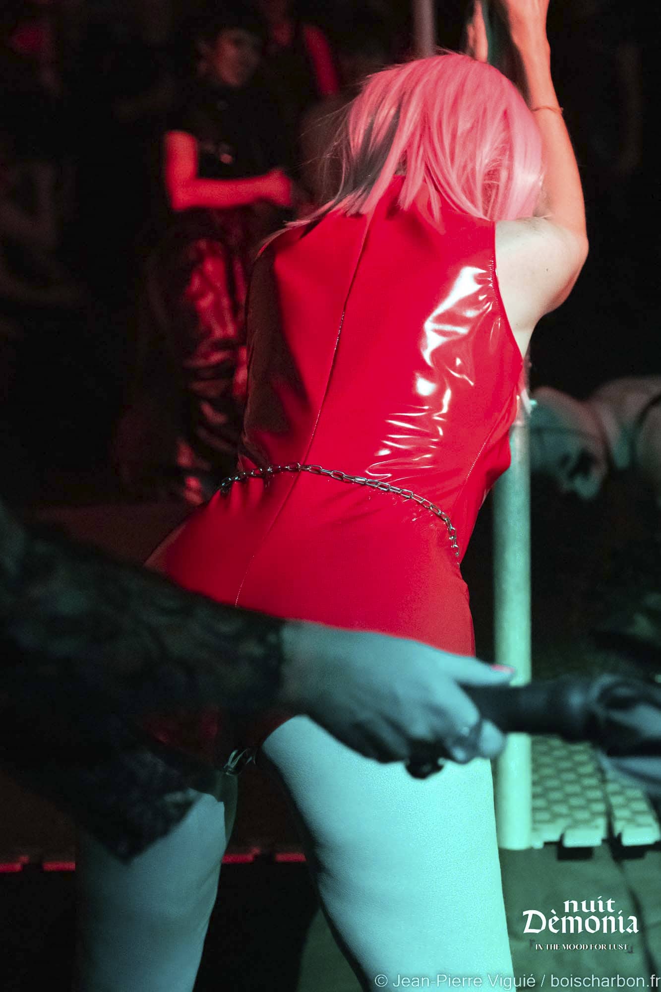 Maîtresse Lumina fouettant avec un martinet en latex une soumise dans le cadre de jeux BDSM